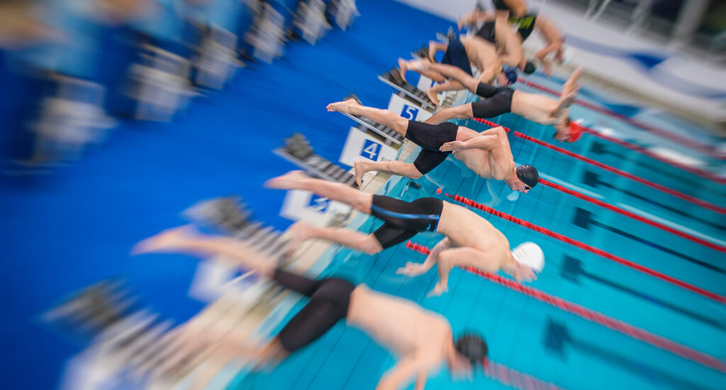 Athletes diving into pool for swimming race