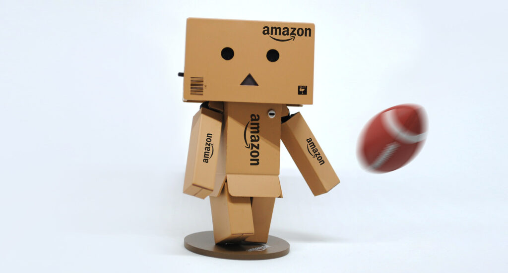 Character made out of Amazon boxes kicking a football