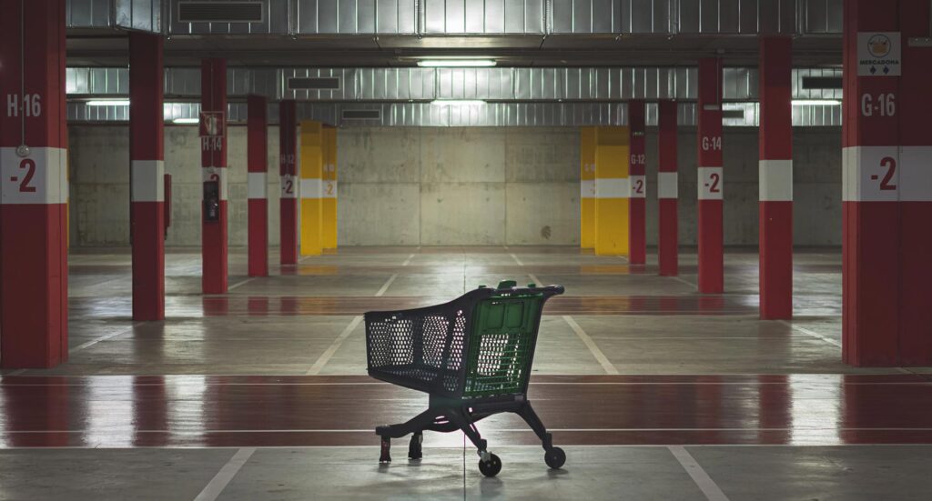 Empty indoor shopping car park with lone shopping trolley